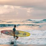 surfer carrying a surfboard